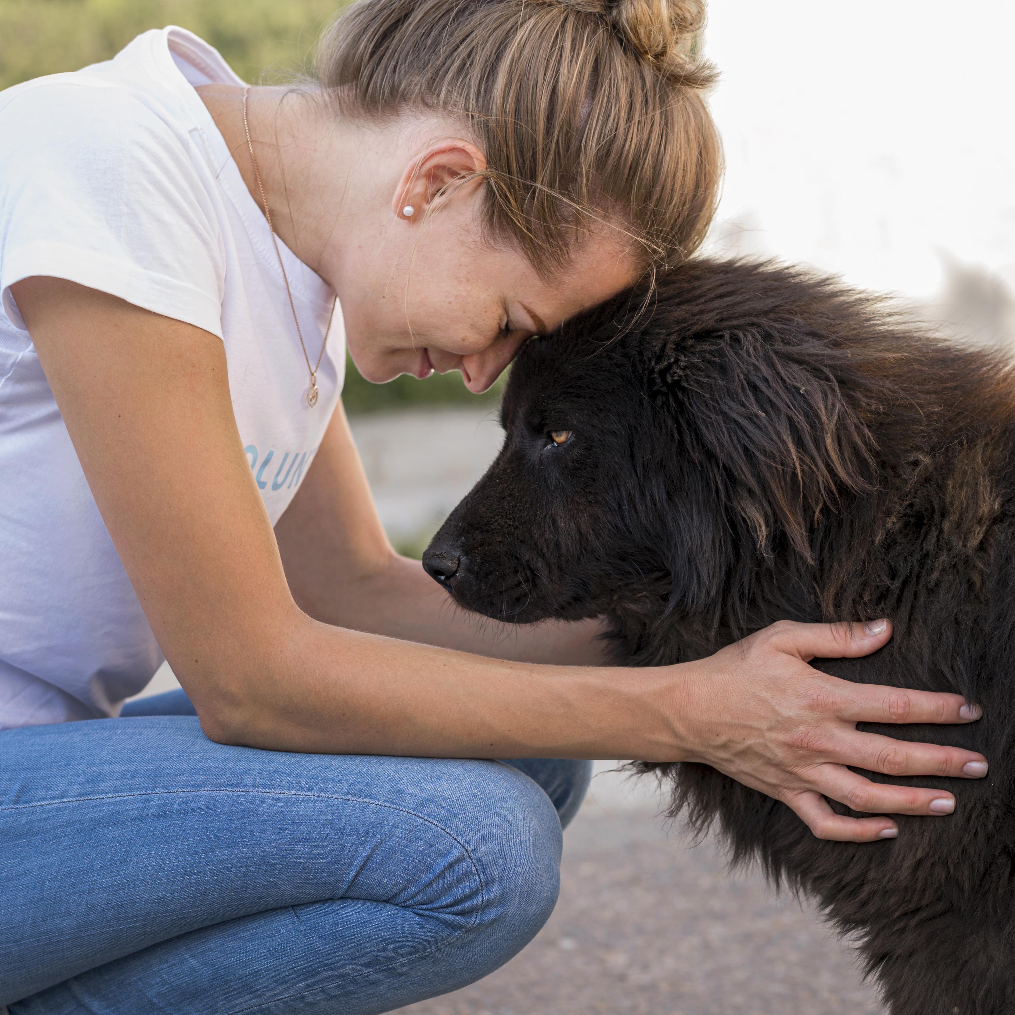 side-view-woman-with-fluffy-black-dog-outdoors